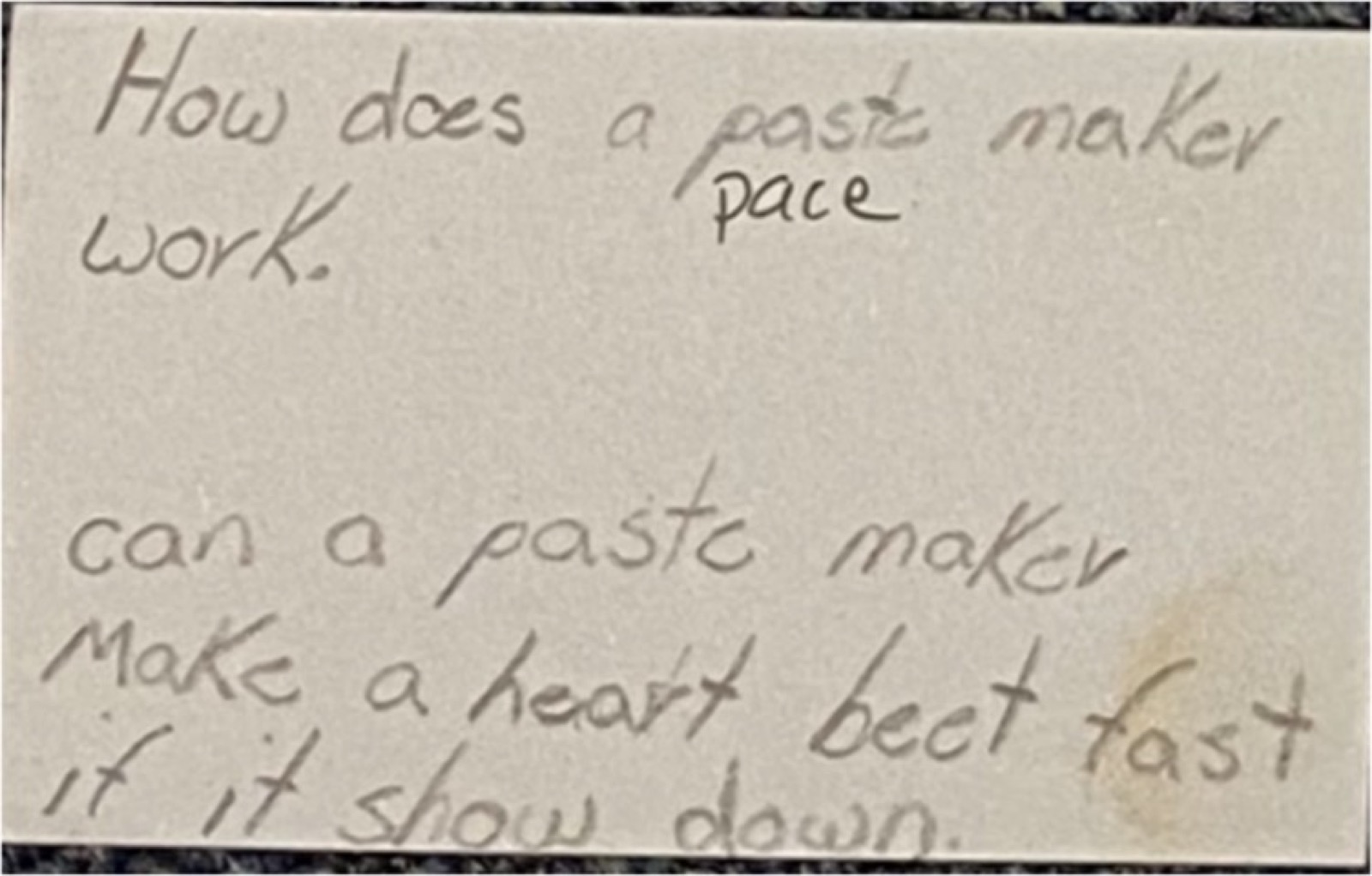Photo d&rsquo;une carte manuscrite, avec des fautes&nbsp;: « How does a paste maker work. Can a paste maker make a heart beet fast if it show down. », le mot « pace » ajouté au-dessus de « paste » (Comment ça marche un pacemakeur&nbsp;? Est-ce qu&rsquo;un pacemakeur peut faire batre un cœur vite si il ralanti&nbsp;?)